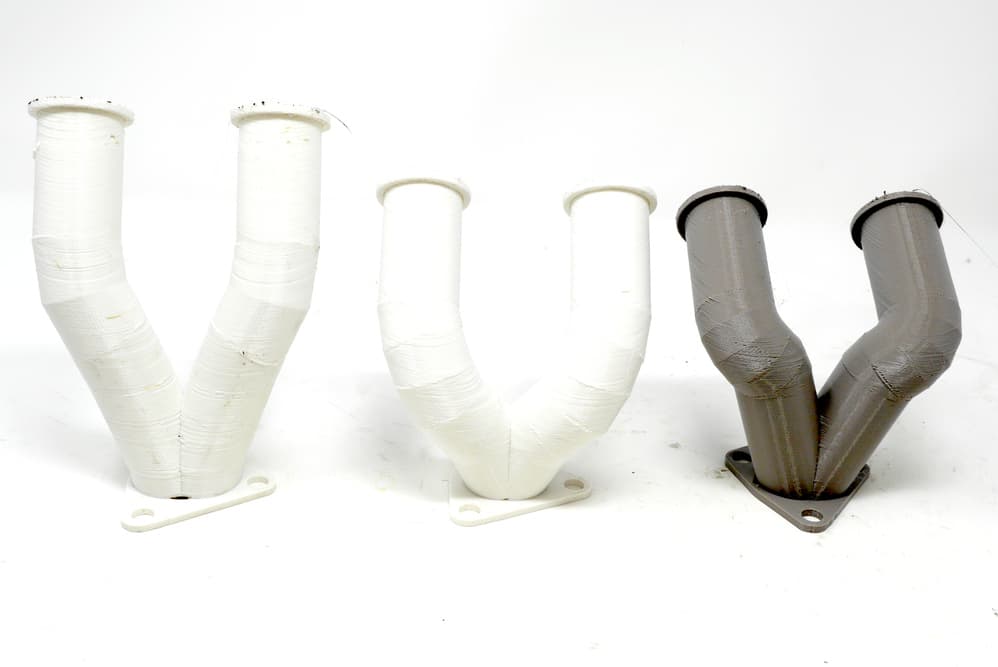 3 iterations of 3d printed exhaust manifold designs